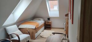 a attic bedroom with a bed and a chair at Ubytovanie Pod Rotundou in Skalica
