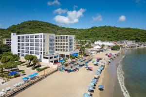 Luftaufnahme eines Strandes mit Gebäuden und Sonnenschirmen in der Unterkunft Decameron La Marina Guayabitos, Ramada All-Inclusive Resort in Rincón de Guayabitos