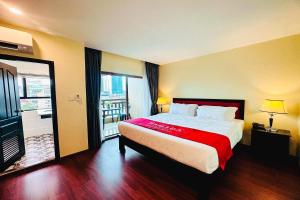 a bedroom with a large bed and a large window at Ramada by Wyndham Phnom Penh Central in Phnom Penh