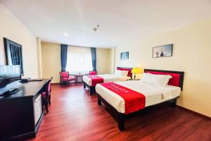 a hotel room with two beds and a flat screen tv at Ramada by Wyndham Phnom Penh Central in Phnom Penh