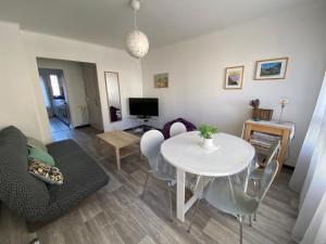 a living room with a white table and chairs at Bel Appartement Residence Mirabeau in Aix-en-Provence