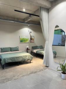 a bedroom with two beds and a window at Phieu Brew Homestay in Hà Tiên