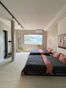 a bedroom with two beds and a large window at Phieu Brew Homestay in Hà Tiên +23 photos
