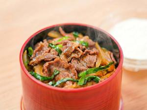 a red bowl of food with meat and vegetables at さめうら荘レイクサイドホテル in Tosa