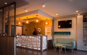 a woman standing at a counter in a room at Reims Hotel in Paris