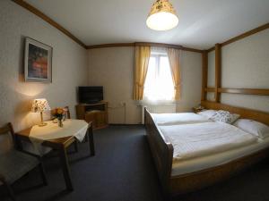 um quarto com 2 camas, uma mesa e uma televisão em Pension Besser em Bad Eisenkappel mais 48 fotografias