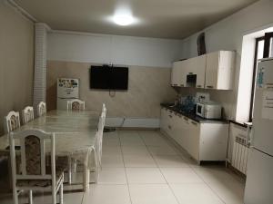 a kitchen with a table and a television in it at Гостиница"Hostel" in Karagandy