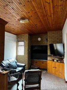 a living room with a couch and a flat screen tv at Casa Bella in Dwarskersbos