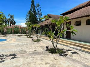 a courtyard with palm trees and a building at 2-Storey with 4BR Villa in a High-End Subdivision in Davao City
