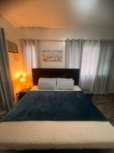a bedroom with a large bed with a blue blanket at 2-Storey with 4BR Villa in a High-End Subdivision in Davao City +39 photos