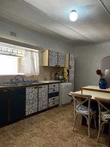 a kitchen with a sink and a table with chairs at Casa Bella in Dwarskersbos