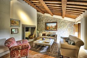 een woonkamer met meubels en een stenen muur bij Villa Collombroso by PosarelliVillas in Porano