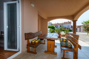 eine Veranda mit einem Holztisch und 2 Stühlen in der Unterkunft Apartments Zdravka in Krk