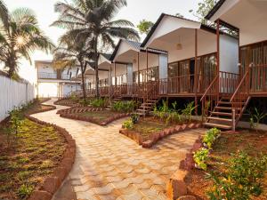 a row of houses with stairs and palm trees at Ananas Beach Resort in Agonda