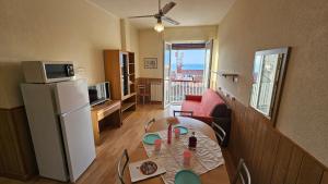a living room with a table and a refrigerator at Residence Olivotti in Finale Ligure