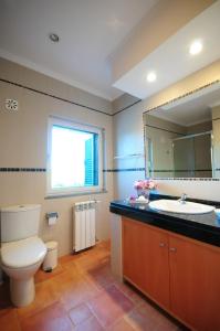a bathroom with a toilet and a sink and a mirror at Hortas de Baixo, Luz de Tavira in Tavira