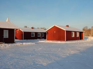 a row of houses with snow on the ground at Burträsk Camping & Stugby in Burträsk