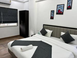 a bedroom with a large bed with two towels on it at Sunny Executive in Satara