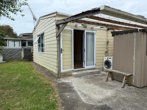 a small house with a washing machine in a yard at Lilys guest house in Auckland