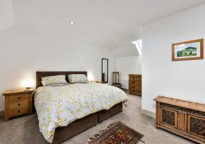 a bedroom with a large bed and a dresser at The Steading at Pitmeadow Farm in Dunning