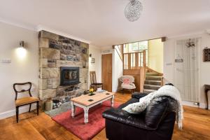 a living room with a leather couch and a fireplace at The Steading at Pitmeadow Farm in Dunning