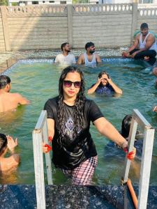 a woman standing in the water in a swimming pool at Kiyanshi Farm in Murbād