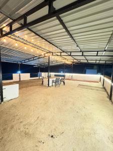 a large empty arena with two benches in it at Kiyanshi Farm in Murbād