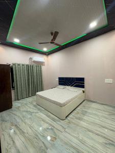 a bedroom with a bed and a ceiling with green lights at Kiyanshi Farm in Murbād