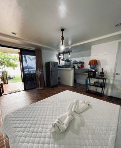 a bedroom with a white bed and a kitchen at John and Novy's beach bungalows in San Francisco