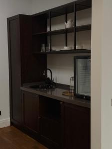 a kitchen with a counter with a sink and a microwave at ЖК Esentai city in Almaty +3 photos