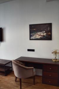 a desk with a chair and a television on a wall at ЖК Esentai city in Almaty