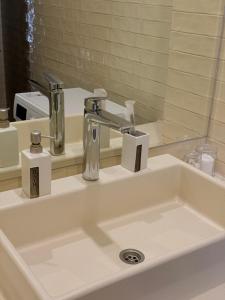 a bathroom sink with a faucet and a mirror at ЖК Esentai city in Almaty