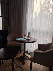 a room with a table and a chair and a window at ЖК Esentai city in Almaty