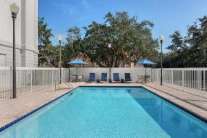 a swimming pool with chairs and umbrellas at Hampton Inn Leesburg Tavares in Leesburg