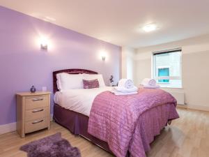 een slaapkamer met een groot bed en een paarse deken bij Baywatch in Poole