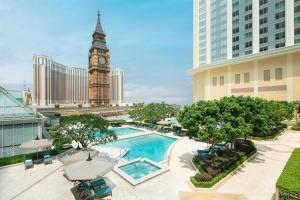 a hotel with a pool and a clock tower at Conrad Macao in Macau