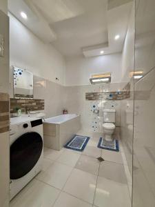 a bathroom with a tub and a toilet and a sink at Getaway Nook in Dedoplis Tskaro