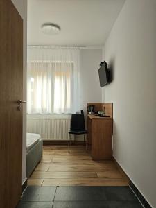 a room with a bed and a desk and a television at Alda Gold in Pyrzowice