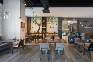 a restaurant with tables and chairs and a bar at Al Maha Arjaan by Rotana in Abu Dhabi