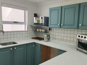 a kitchen with blue cabinets and a sink at Mia Nina in Heatherlands