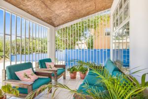 a screened porch with blue chairs and plants at The blue wave in Willemstad