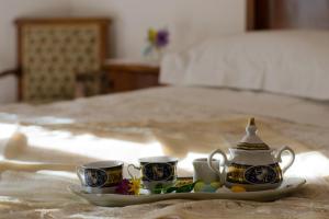 a plate with two cups and eggs on a bed at La piccola casa del cinema in Giffoni Valle Piana