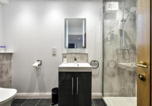 a bathroom with a sink and a shower at The Studio at Pitmeadow Farm in Dunning +22 photos