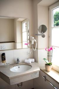 ein Bad mit einem Waschbecken und einem Spiegel in der Unterkunft Gasthof Engel in Kaufbeuren