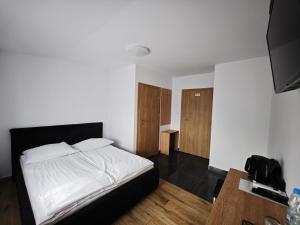 a bedroom with a white bed and wooden floors at Alda Gold in Pyrzowice