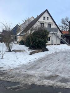 a house with snow in front of a driveway at OK-City in Bayreuth