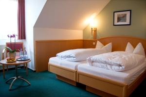 a hotel room with two beds and a table at Gasthof Engel in Kaufbeuren