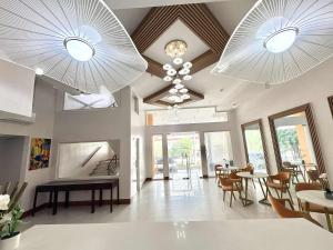 a living room with two chandeliers and a table and chairs at Palette Cebu The Almonds Boutique Aparthotel Near University of Cebu in Cebu City