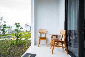 two chairs and a table in a room with a window at Villa Jepun Segara Giri in Kubupenlokan