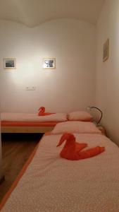 2 Betten in einem Zimmer mit roten Tieren drauf in der Unterkunft Apartmán v Zahradní in Prachatice